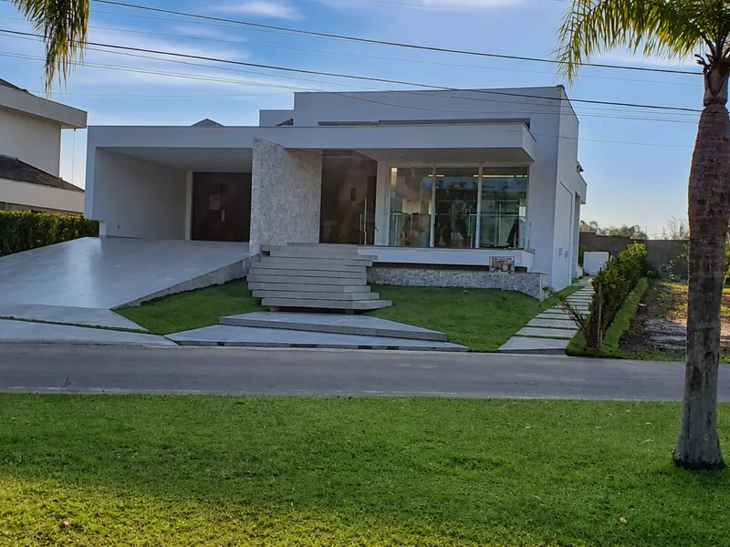 Residência em contraluz no fim da tarde, fachada e jardim